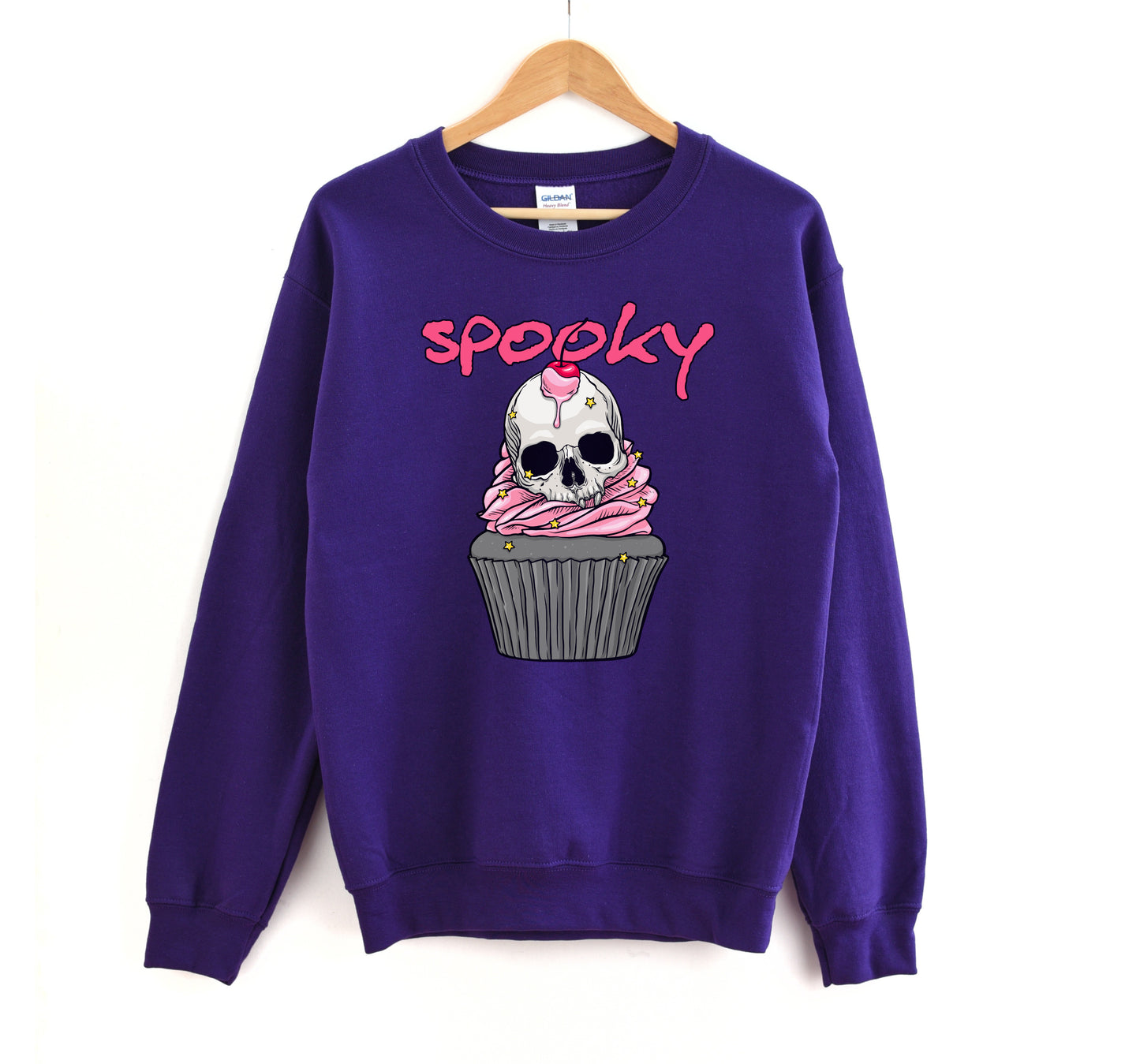 Purple sweatshirt with a skull cupcake design and 'spooky' text on a white background