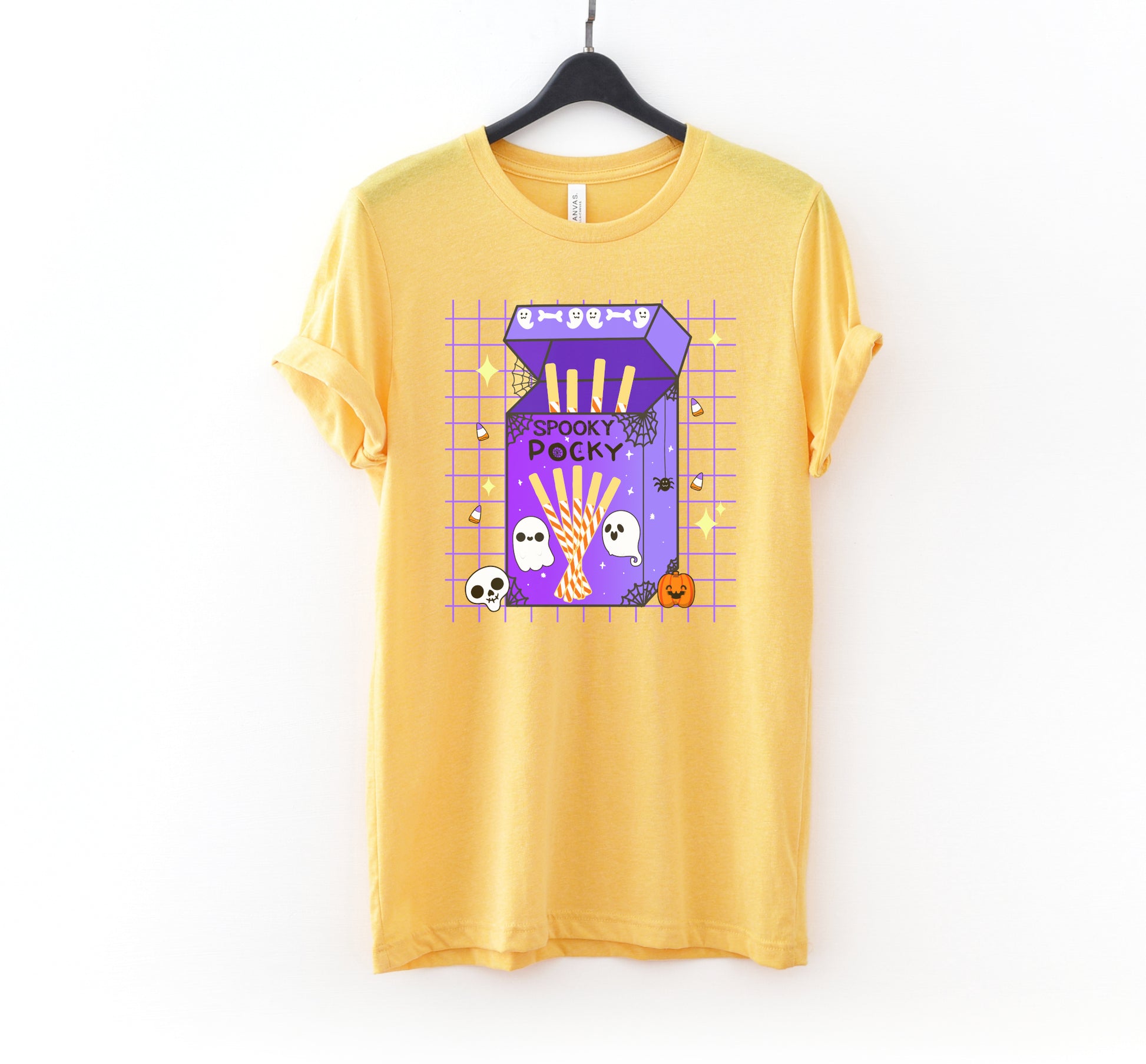 Yellow t-shirt with a Halloween-themed design on a hanger against a white background